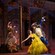 Artistas disfrazados de Belle y Beast bailan cerca de otros artistas disfrazados de Lumière y Cogsworth